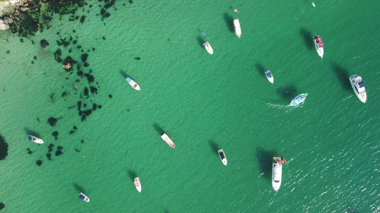 空中海景全景，清澈湛蓝的大海和岩石海岸。在岩石衬托下的美丽泻湖中的游艇。理想的夏季旅游度假目的地的概念视频素材