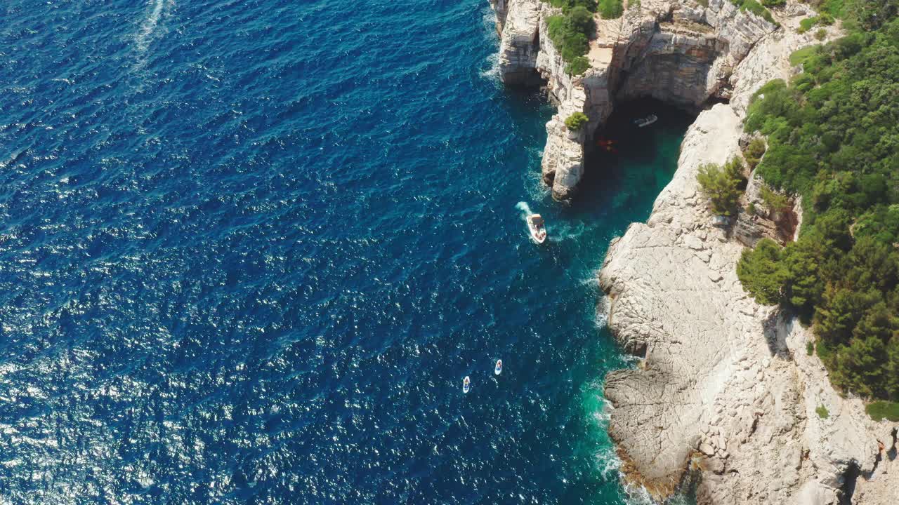 摩托艇在海上航行，经过度假胜地海岸上的悬崖视频素材