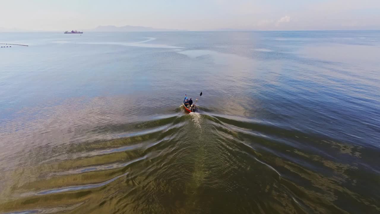 从无人机摄像机高空鸟瞰清晨从海滩到海洋潜水的渔船视频素材