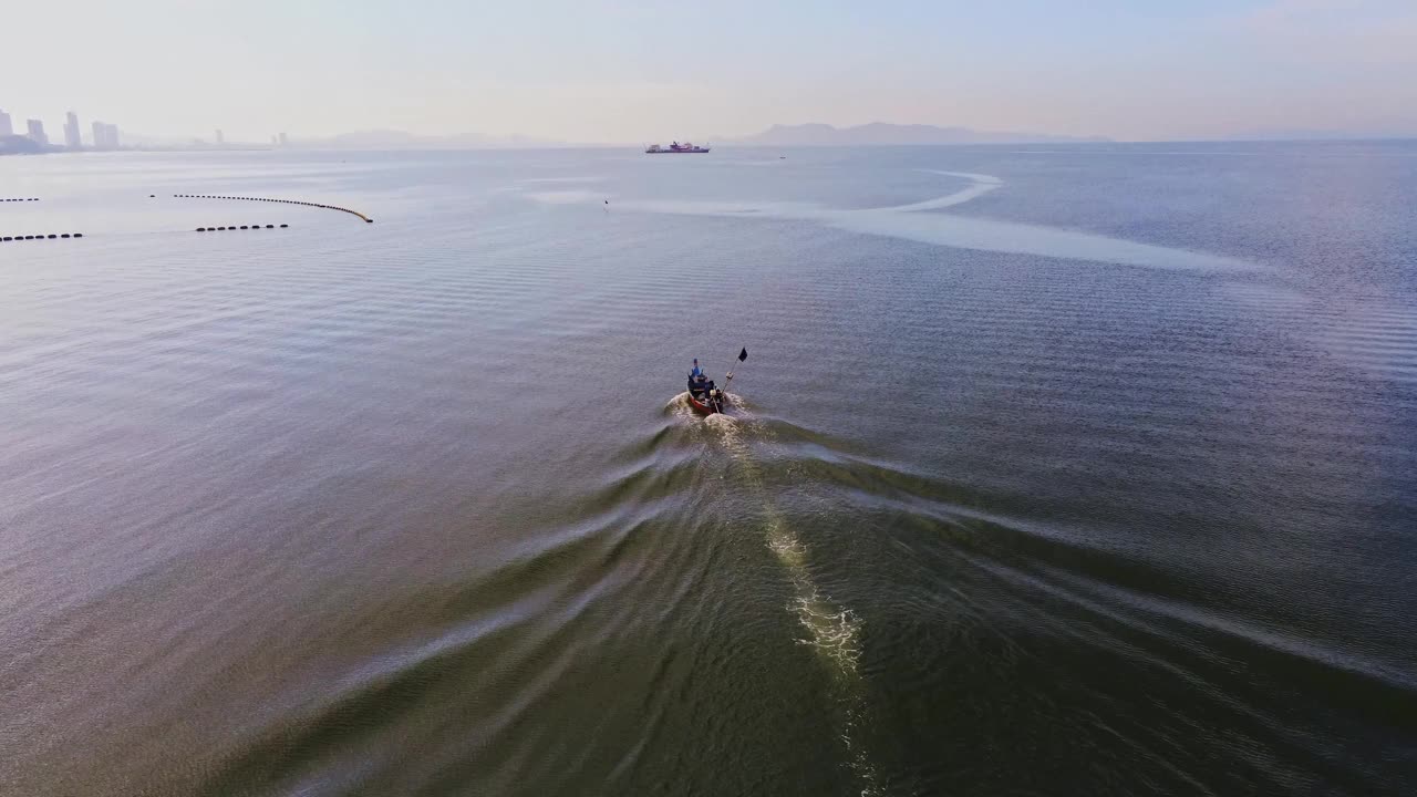 从无人机摄像机高空鸟瞰清晨从海滩到海洋潜水的渔船视频素材