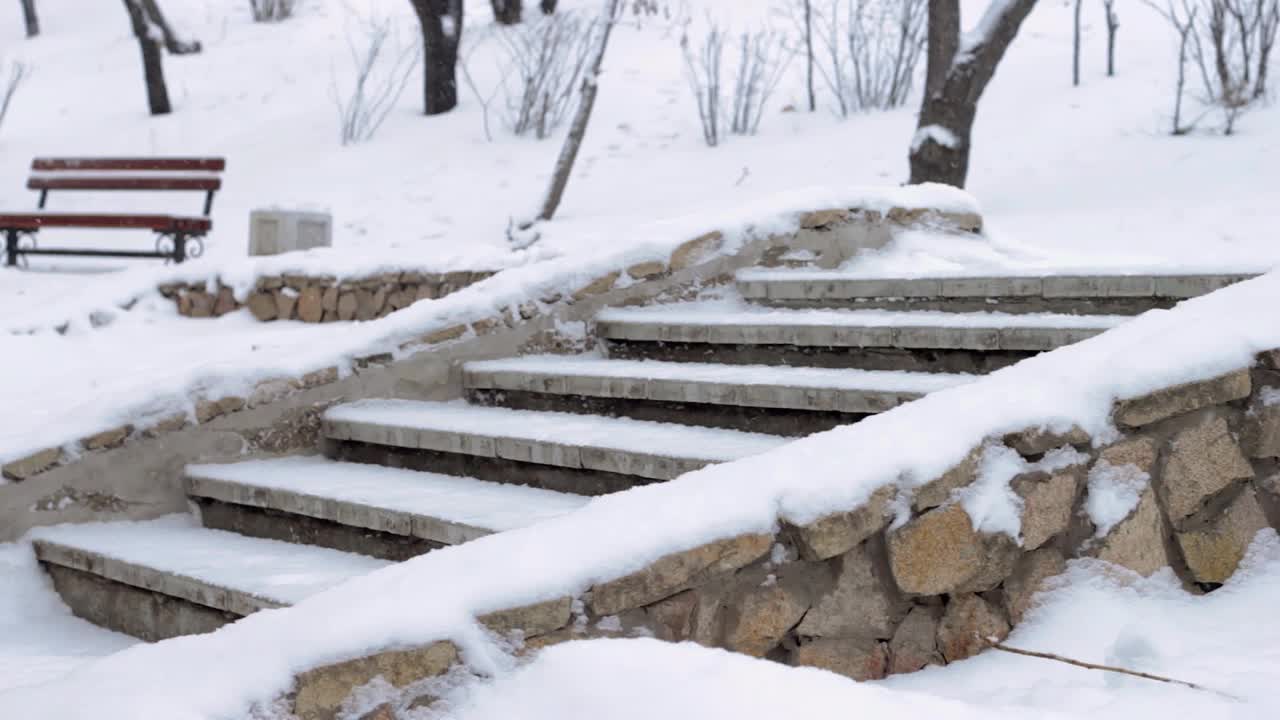 冬天公园下雪，在寒冷的雪季用雪堆砌筑楼梯视频下载