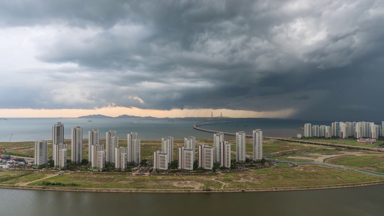 ▽白天=仁川松岛国际商圈(延寿区)松岛地标城市(Songdo Landmark City)的西海仁川大桥和松岛海滨附近的公寓上空乌云密布视频素材