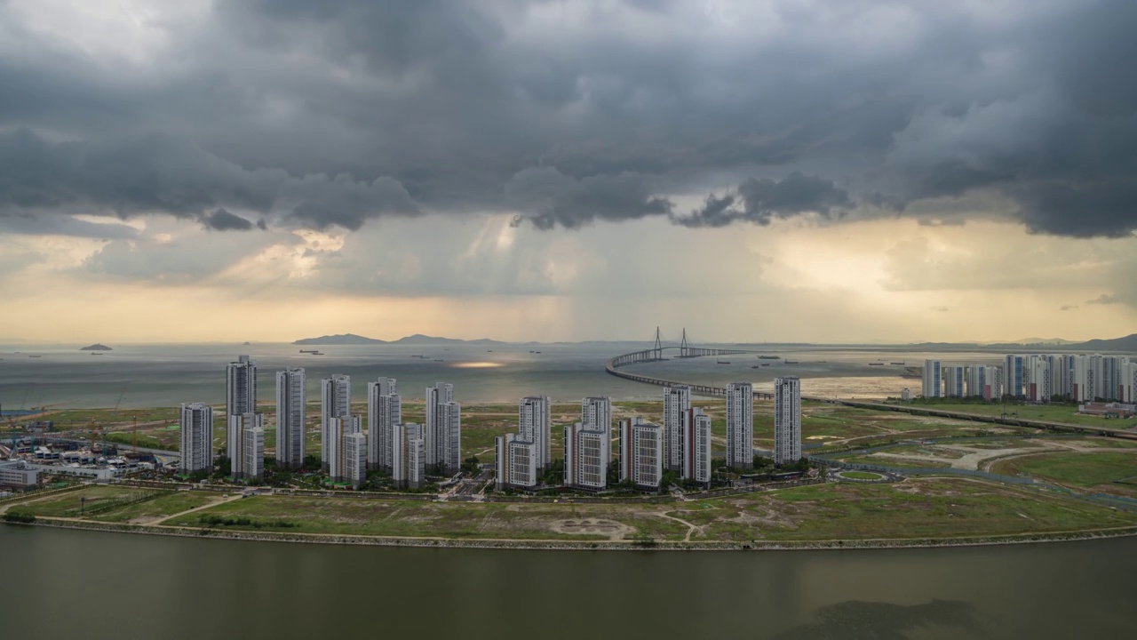 ▽白天=仁川松岛国际商圈(延寿区)松岛地标城市(Songdo Landmark City)的西海仁川大桥和松岛海滨附近的公寓上空乌云密布视频素材