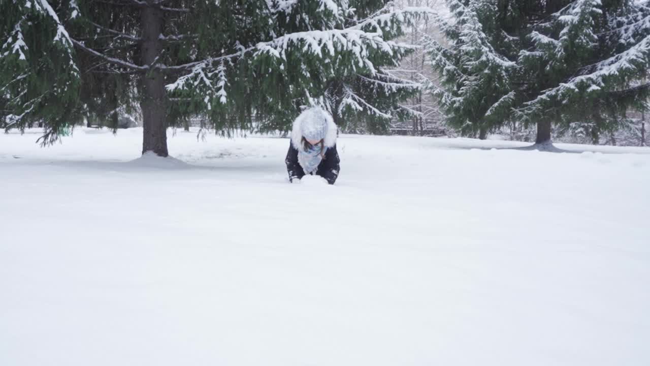 一个十几岁的女孩在公园里玩的时候扔出了新鲜的雪视频素材