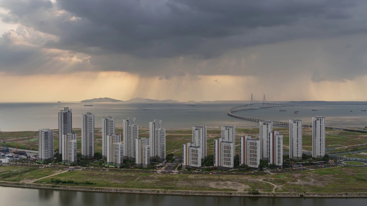 ▽白天=仁川松岛国际商圈(延寿区)松岛地标城市(Songdo Landmark City)的西海仁川大桥和松岛海滨附近的公寓上空乌云密布视频素材