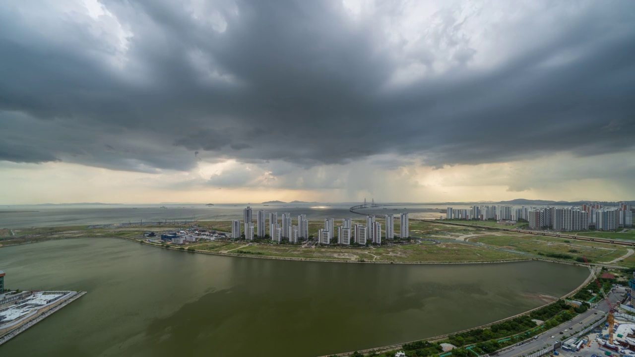 ▽白天=仁川松岛国际商圈(延寿区)松岛地标城市(Songdo Landmark City)的西海仁川大桥和松岛海滨附近的公寓上空乌云密布视频素材