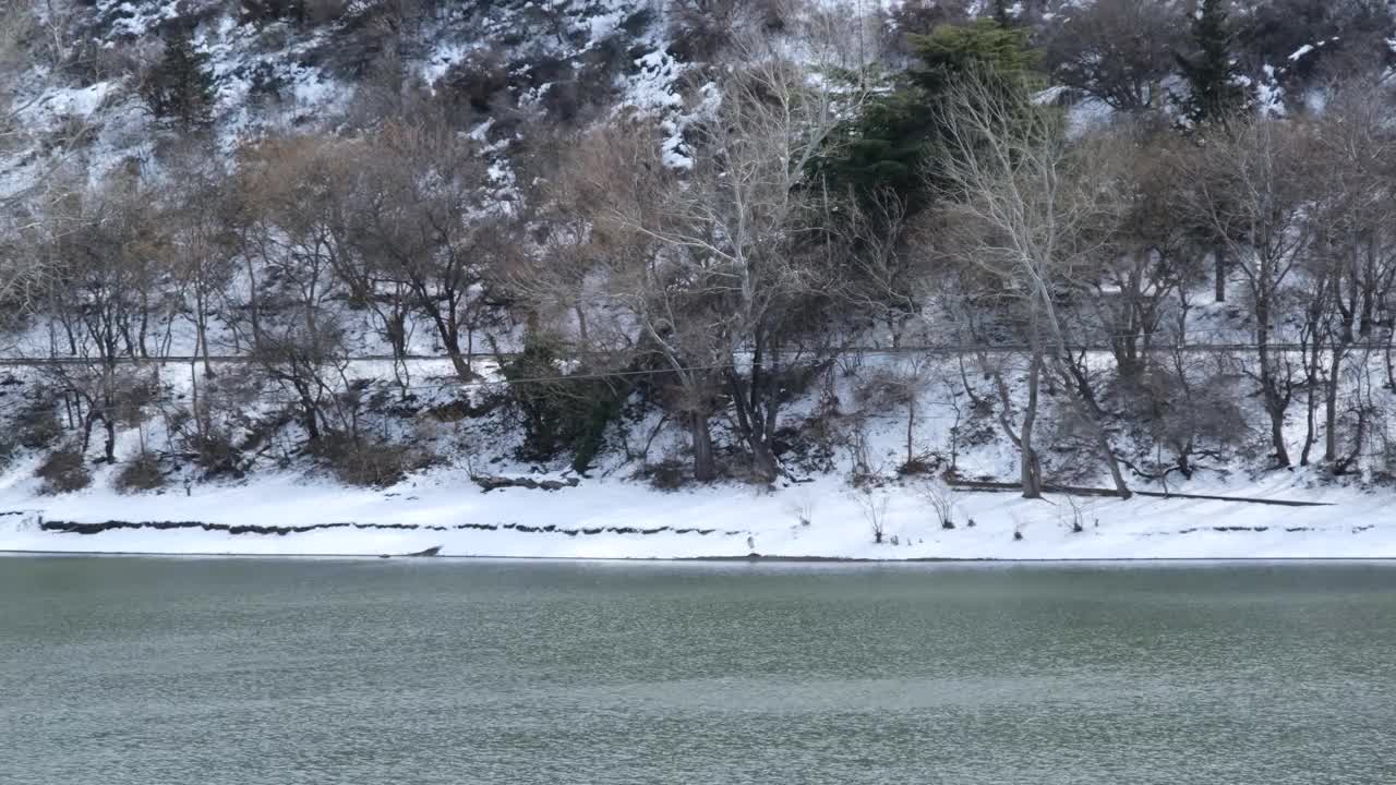 雪山湖。冰雪覆盖的山湖岸边的冬季景观。冬天的风景视频素材