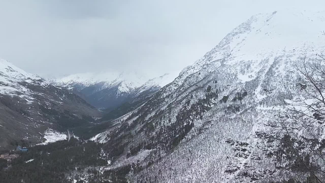 缓慢的运动。山顶积雪覆盖的山坡和山谷的俯视图视频下载