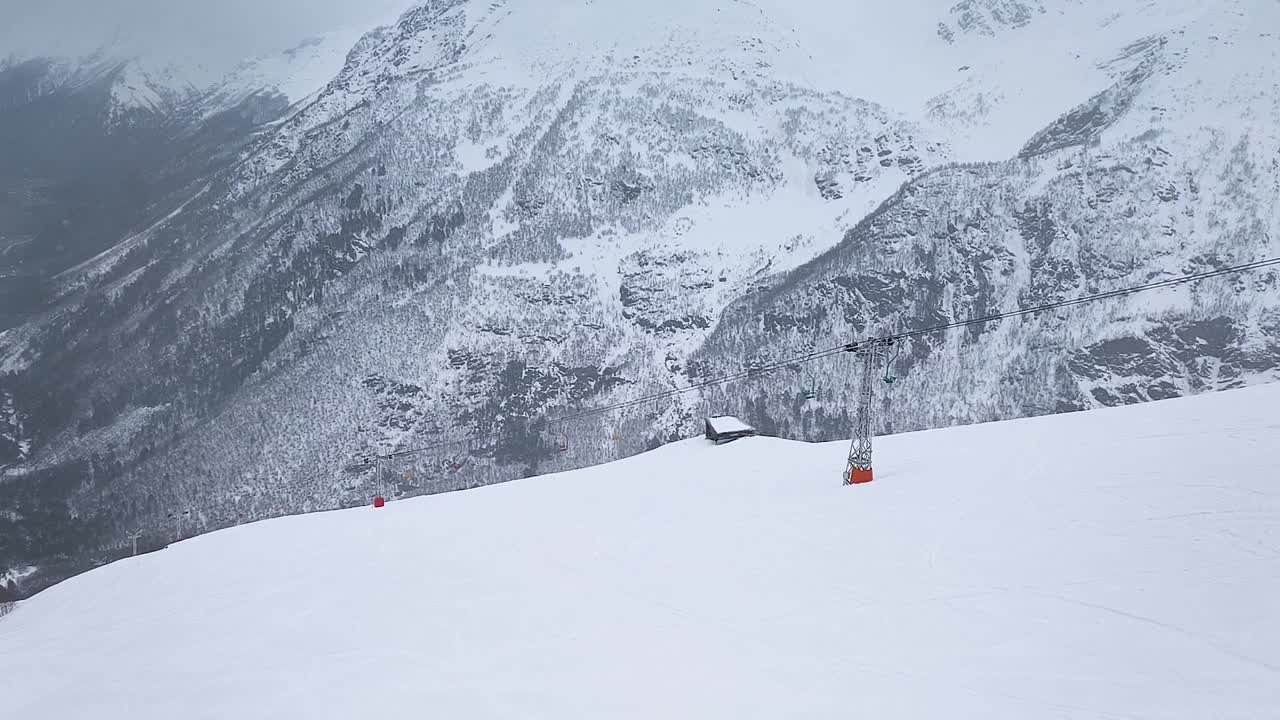 缓慢的运动。无人驾驶飞机射击。山顶度假村滑雪坡道和缆车的俯视图视频素材