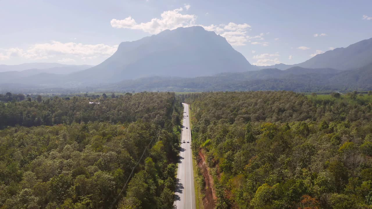 鸟瞰图的空的道路或街道到Doi Luang Chiang Dao，清迈的山上有绿色的天然森林树木在农村地区，泰国。交通工具。自然环境背景视频素材