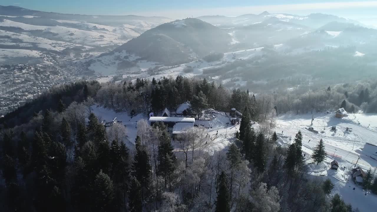 鸟瞰图的滑雪斜坡和滑雪者滑雪下的斜坡。美丽的滑雪胜地，有滑雪缆车，冬天的风景有新鲜的白雪。寒假里阳光明媚的一天。完美的滑雪条件。视频素材