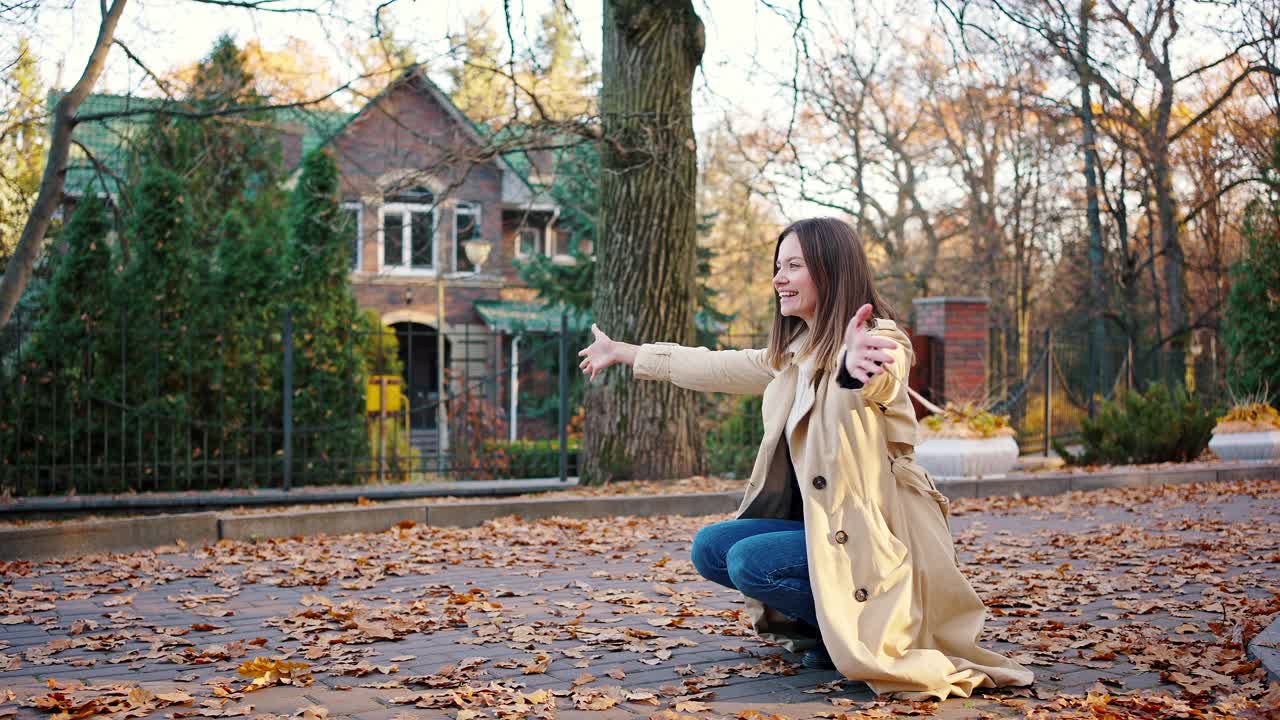 小女孩穿着休闲的衣服和背包跑向微笑的妈妈，拥抱她。秋季的一天,公园。慢动作视频素材