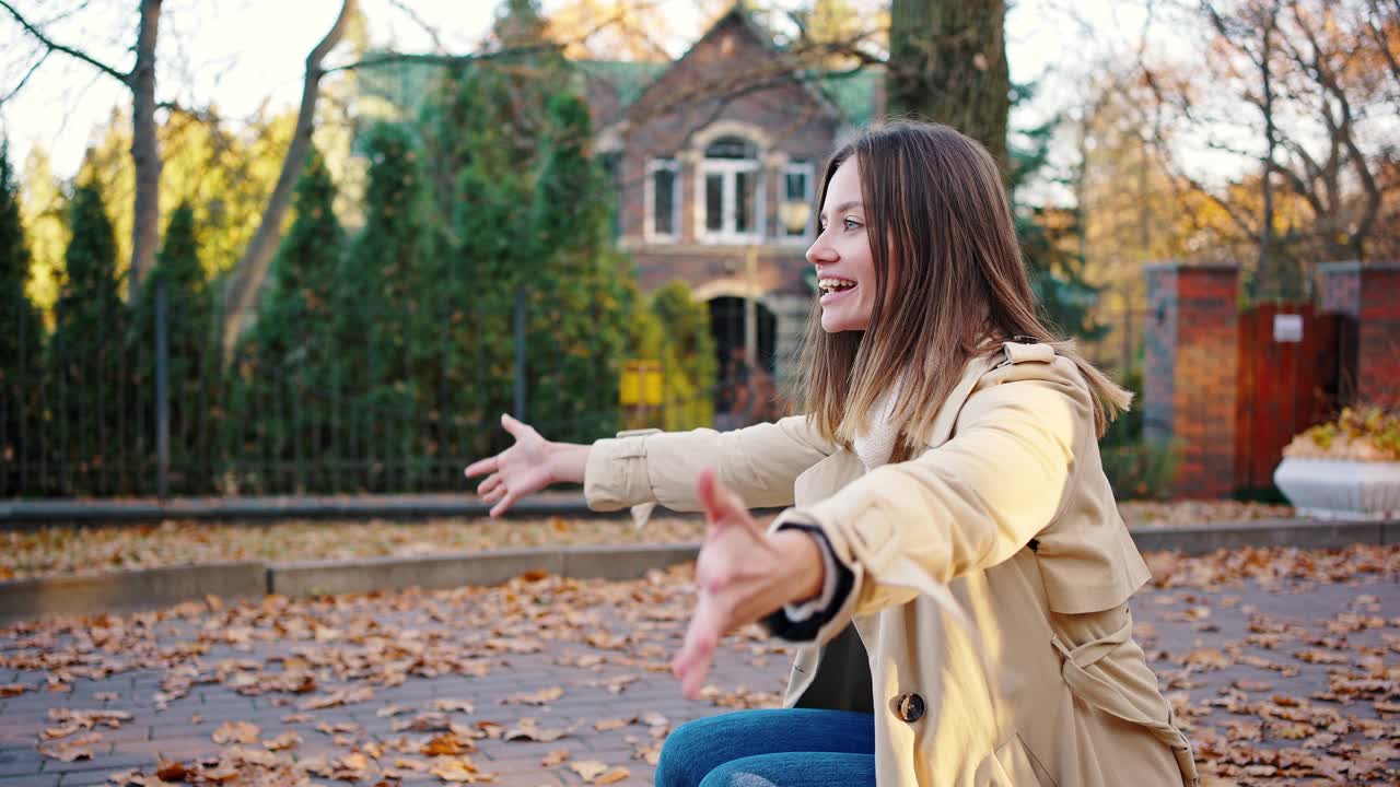 小女孩，穿着休闲装，背着背包，跑向微笑的妈妈，拥抱她。秋季的一天,公园。特写，慢动作视频素材