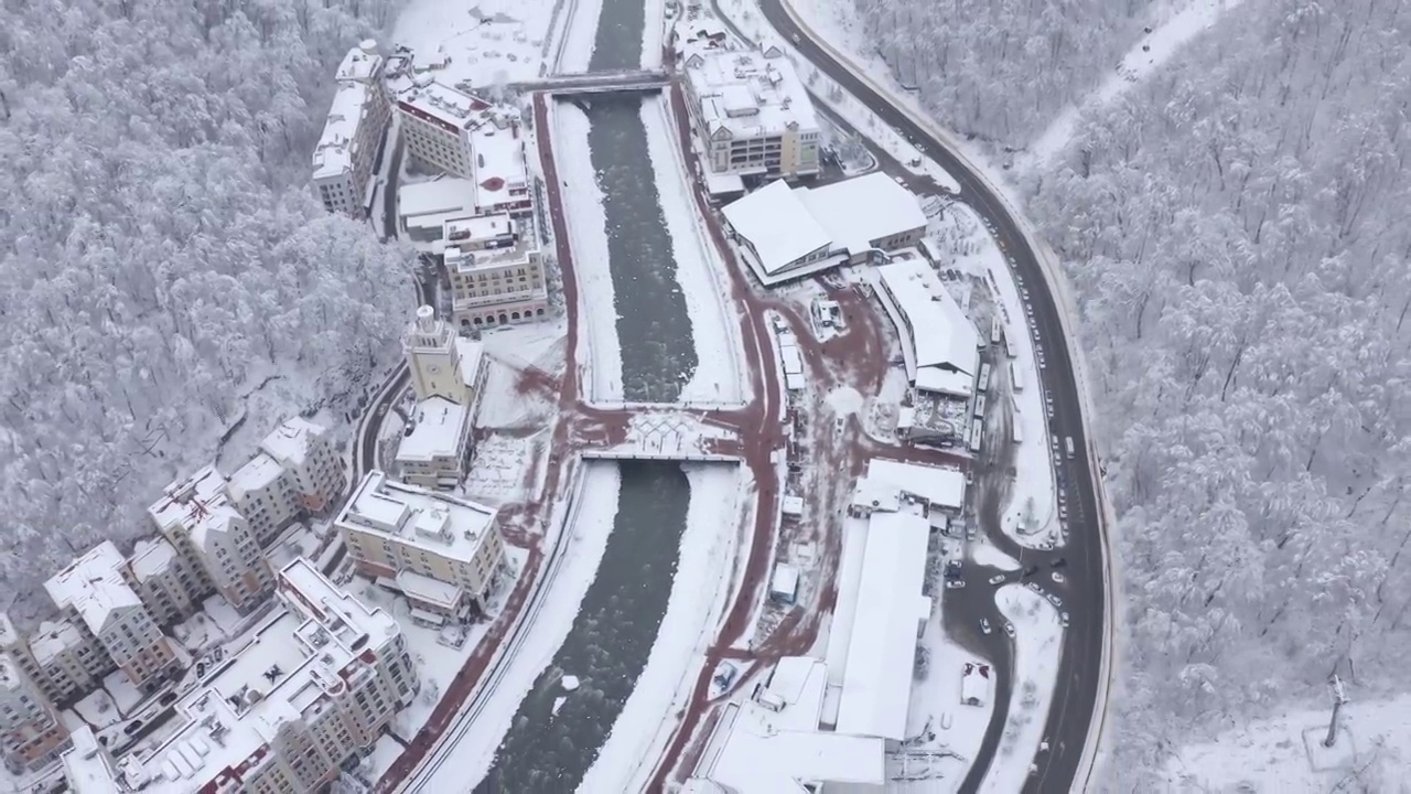 空中俯瞰冬季城市滑雪度假村被高山景色包围视频素材