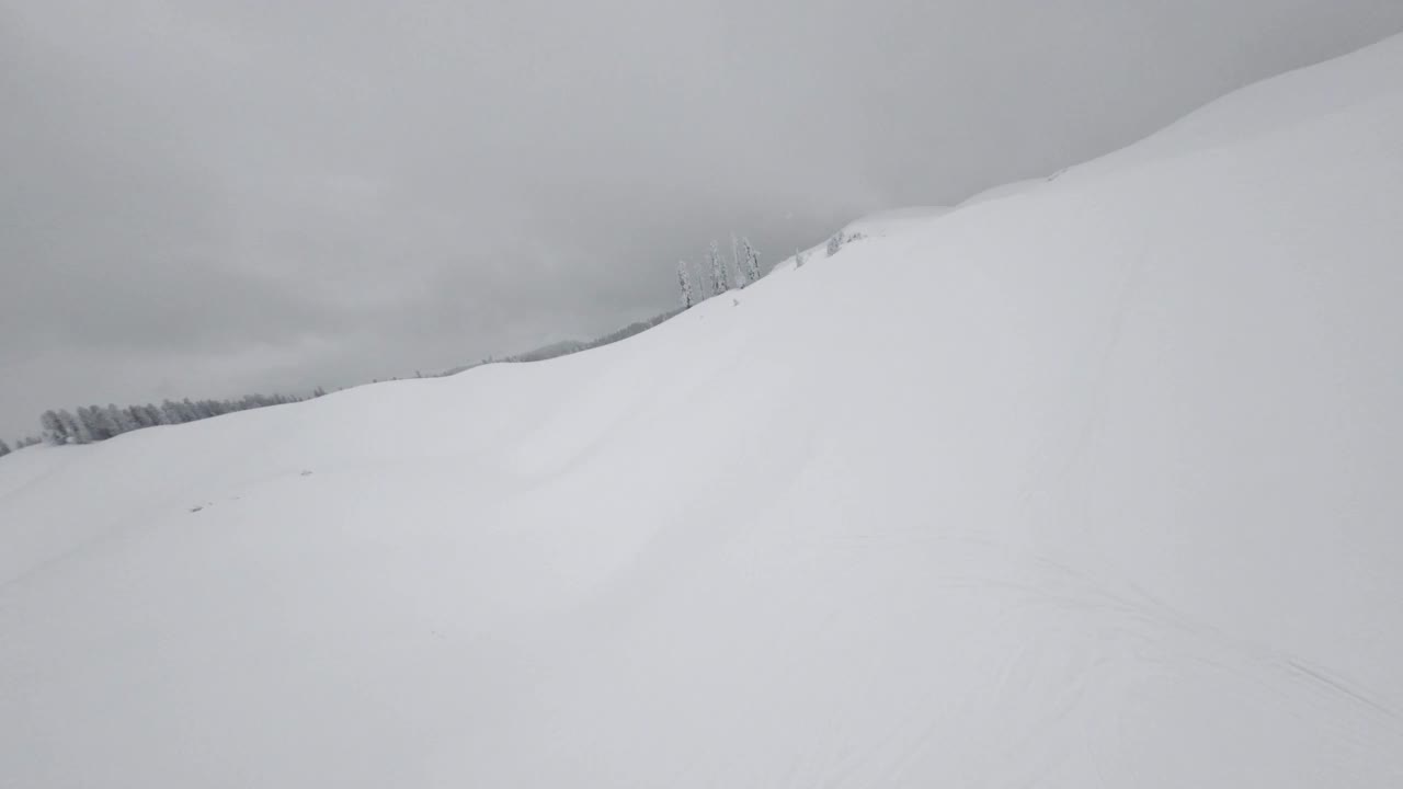 鸟瞰运动fpv无人机荒野雪区阿布哈兹，Mamdziskha山与暴风雪视频素材