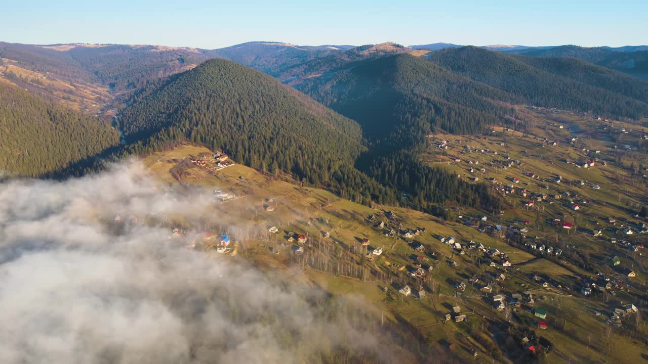 从上面看日出时云雾笼罩着小山和村舍的充满活力的景观视频素材