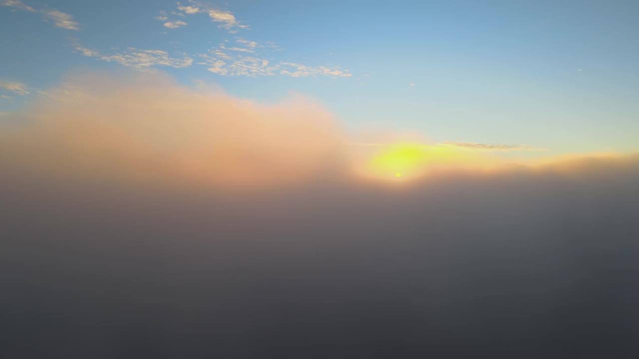 鸟瞰图中充满活力的日出在白色浓雾中，远处地平线上是喀尔巴阡山脉的黑色山峰。视频素材