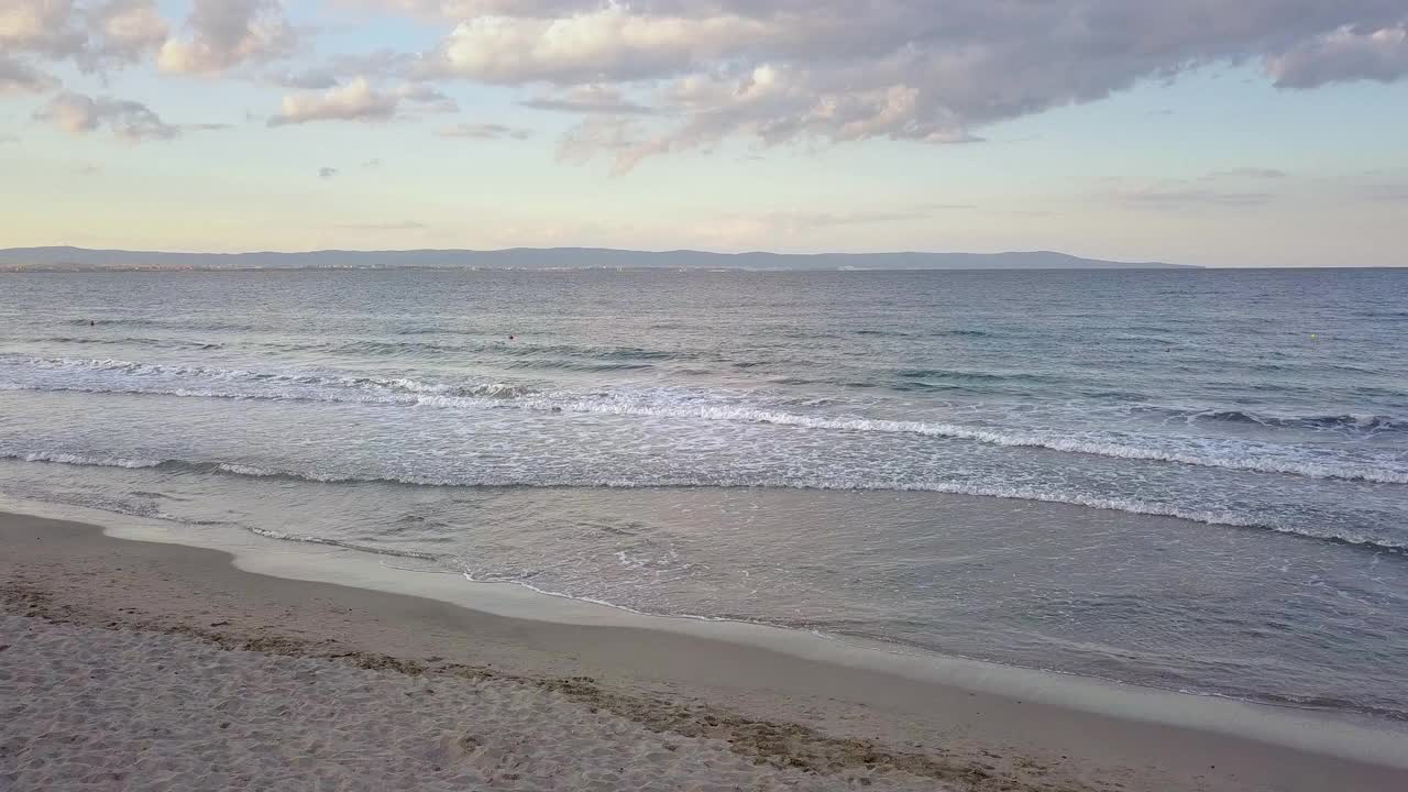 鸟瞰图的海面与蓝色的水波浪下日落的天空视频素材