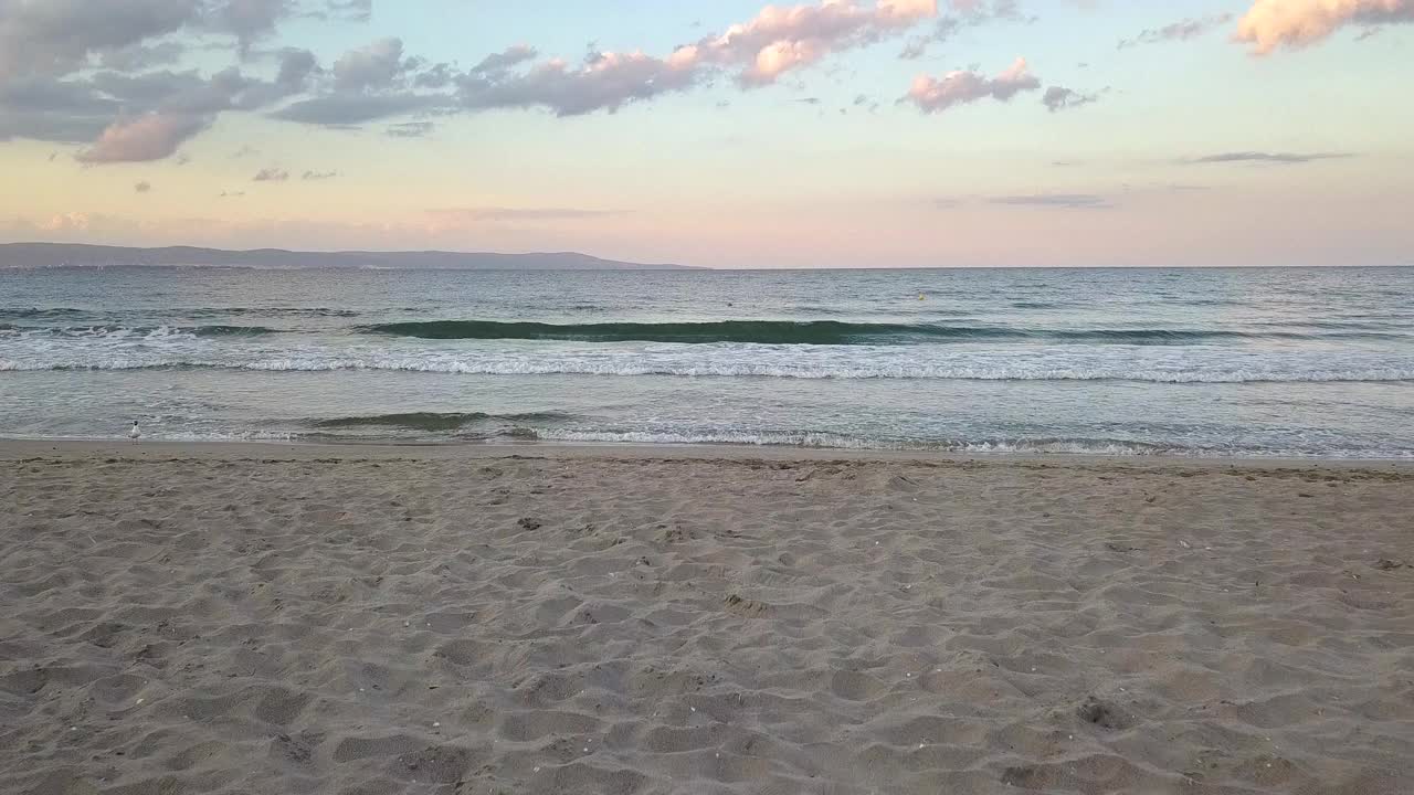 鸟瞰图的海面与蓝色的水波浪下日落的天空视频素材