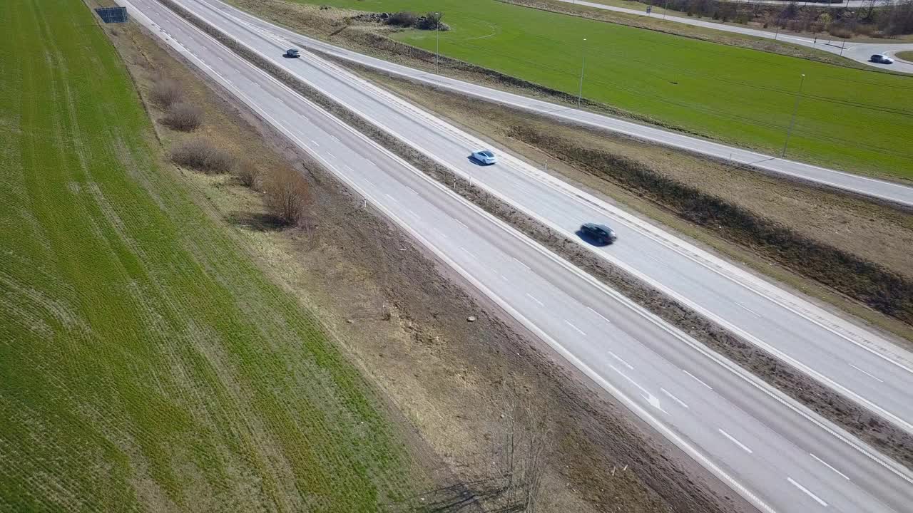 高速公路，在绿地之间行驶的汽车。视频素材