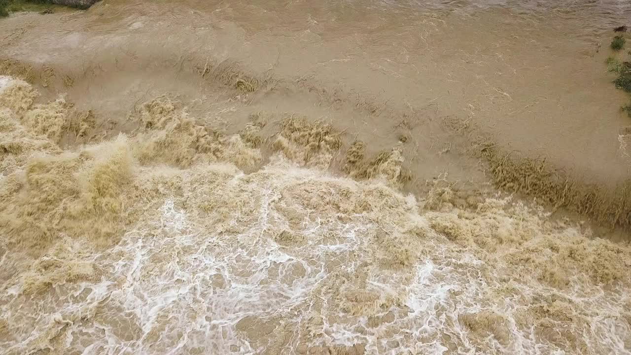 鸟瞰图:在春季暴雨期间，河水泛滥，河水浑浊。视频素材