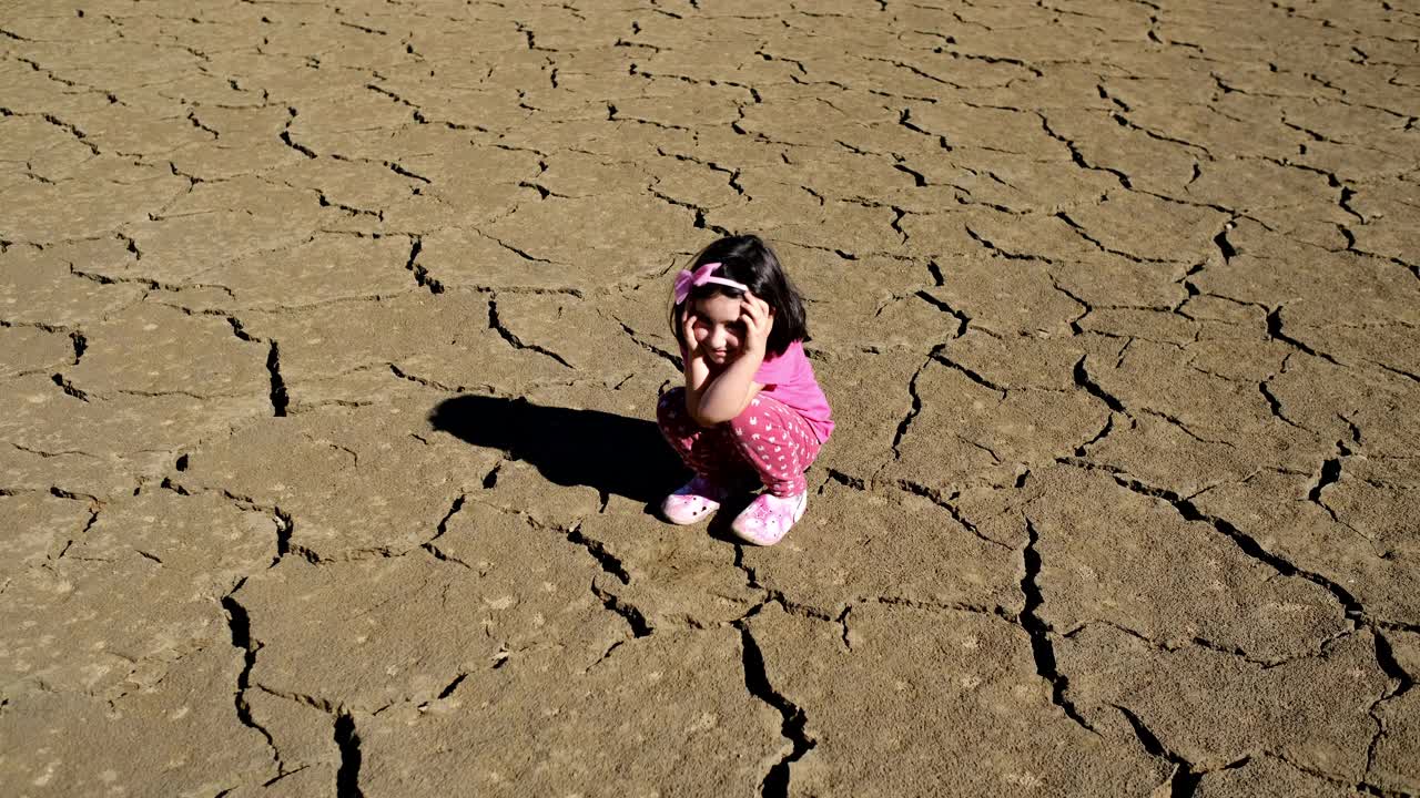 一个孩子在干裂的大地上视频素材