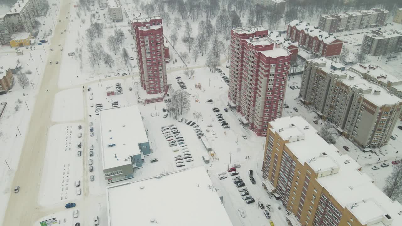 高层住宅建筑和城市道路被白雪覆盖。视频素材