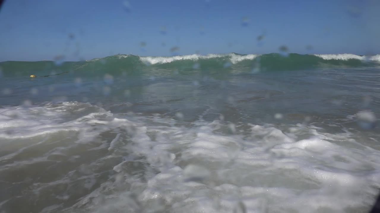 照相机在淹没的大海里，既浸在水里，又浸在海的上面。美丽的光线在水面折射，潜水、浮潜都是如此。视频素材