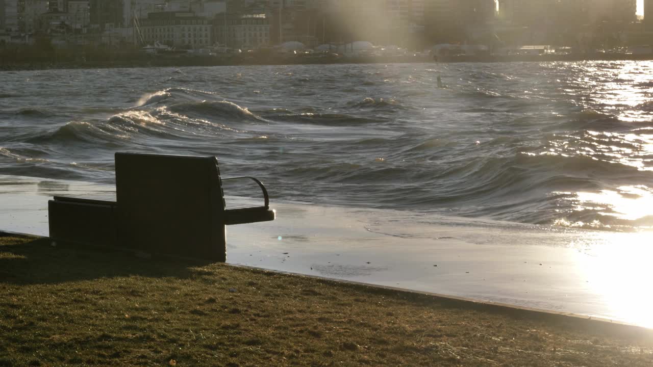 海浪拍打着海岸。公园里的长椅在画框里视频下载