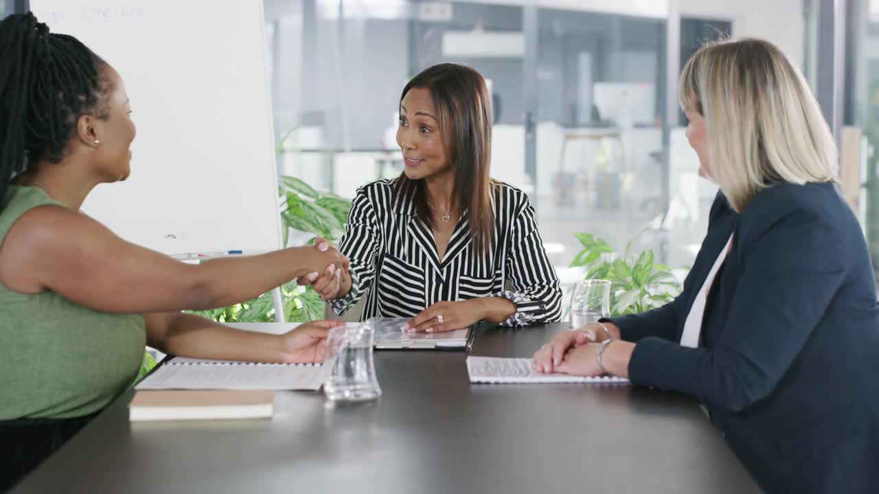 在一间现代化的董事会会议室里，女商人在会议中握手的4k视频片段视频素材