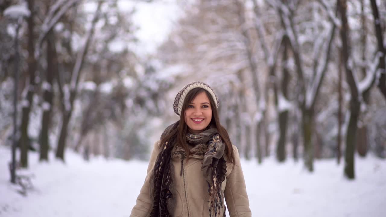 快乐的女人在白雪公园里张开双臂视频素材