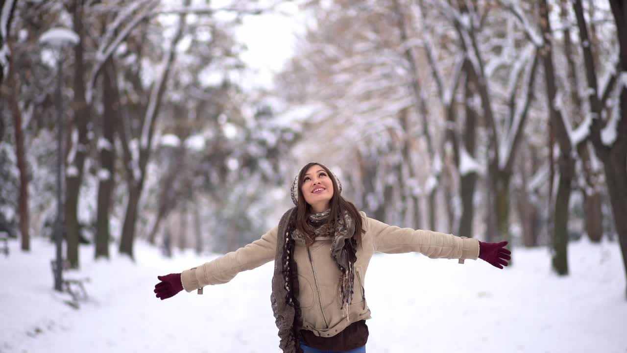 快乐的女人在雪地公园旋转视频素材