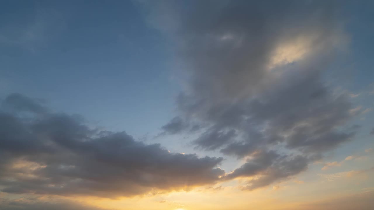 日落天空的时间流逝。抽象的自然背景。戏剧性的蓝色与橙色的云在黄昏时间。视频素材