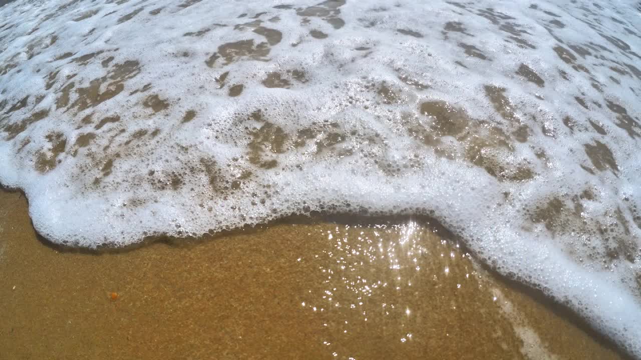 海浪卷上白沙海滩的特写镜头视频素材