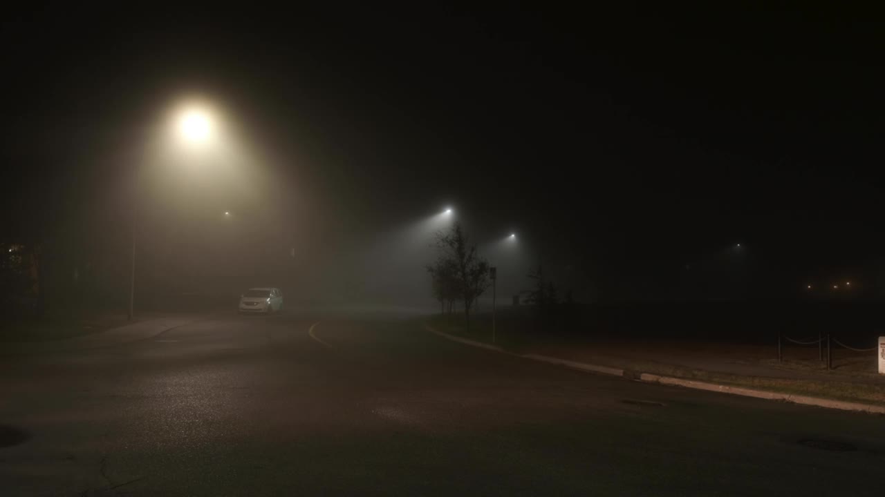 多雾的夜晚，车辆稀少的城市街道视频素材