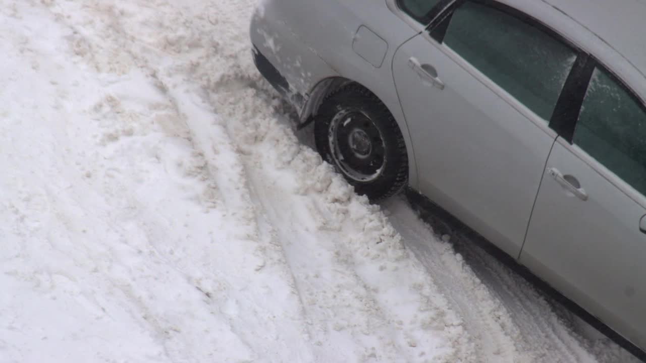 冬天路上结了冰，汽车在雪中打滑。严重的暴风雪,雪堆视频素材