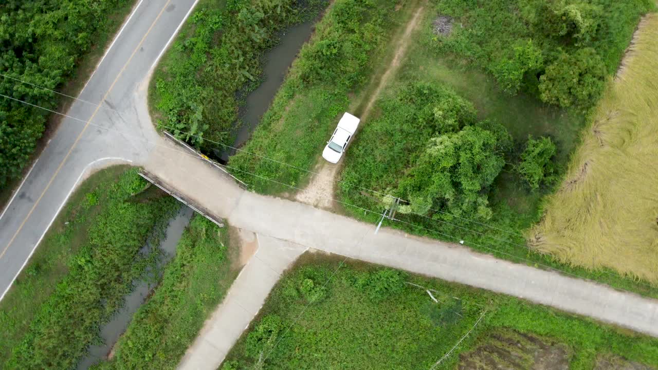 旋转:沿着乡村公路在田野上空飞行。视频素材