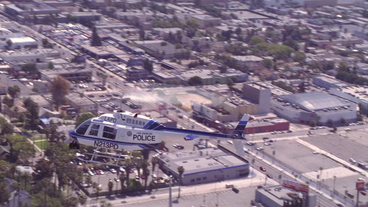 “lapd n213pd”的空中飞行或盘旋在国会大厦附近记录建筑地标。好莱坞。好莱坞大道6253号高层、塔夫脱大厦、树木、城市街道、汽车、多层办公楼、住宅和停车场均可见。可能是给警察的视频素材