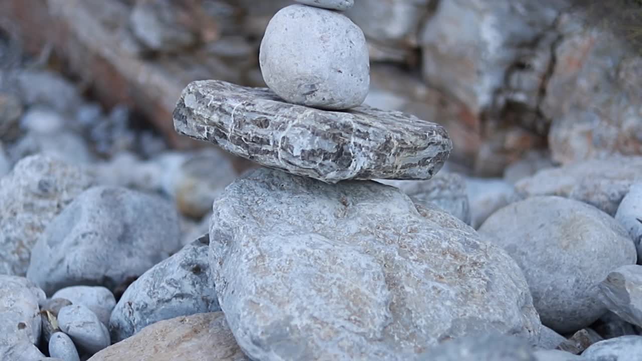 禅宗冥想的背景-平衡的石头堆砌cairn接近海滩。视频素材