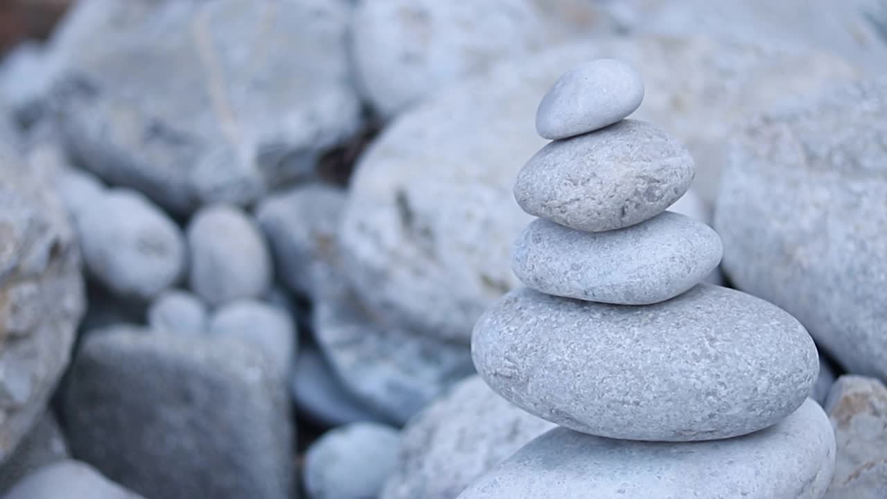 禅宗冥想的背景-平衡的石头堆砌cairn接近海滩。视频素材