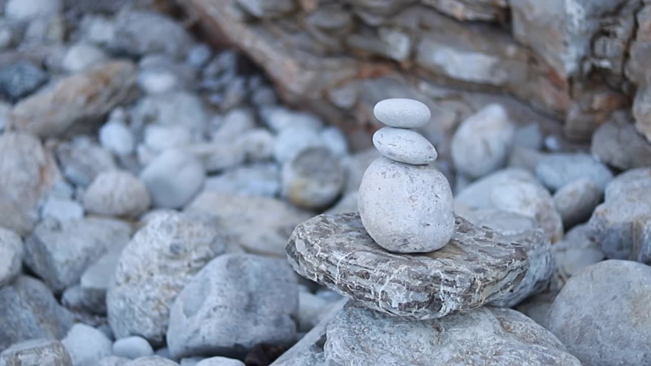 禅宗冥想的背景-平衡的石头堆砌cairn接近海滩。视频素材