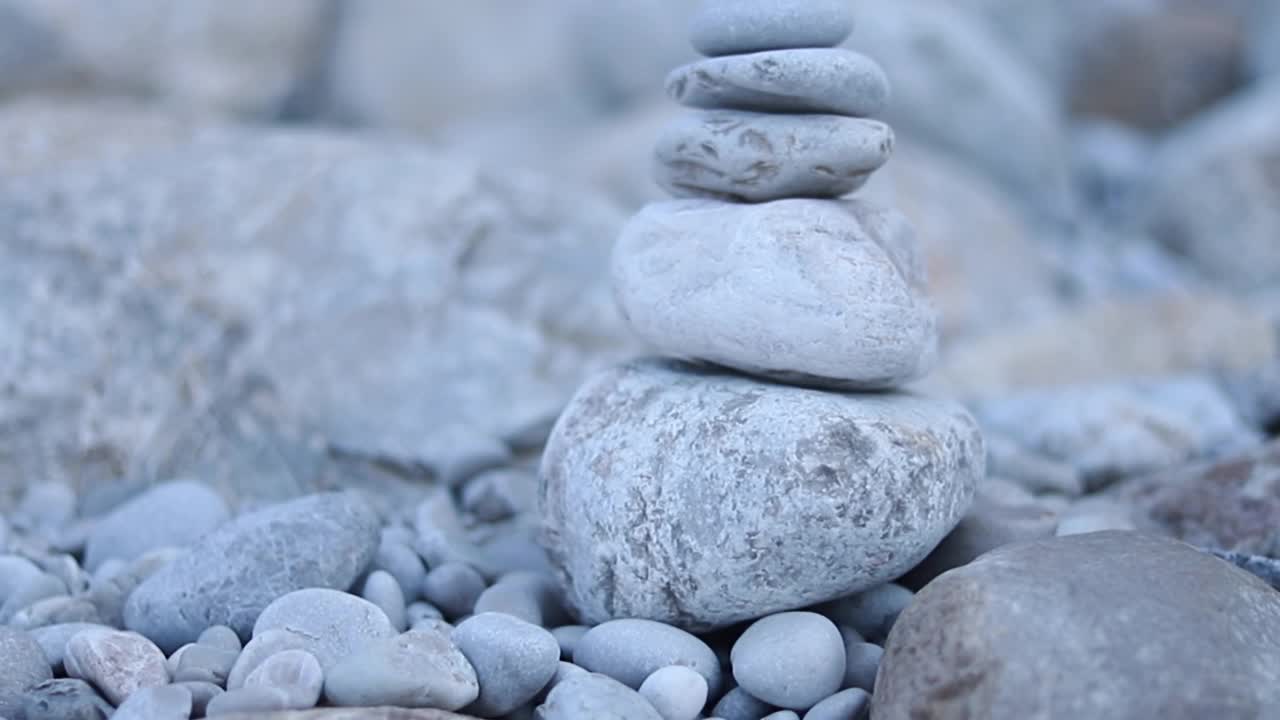 禅宗冥想的背景-平衡的石头堆砌cairn接近海滩。视频素材