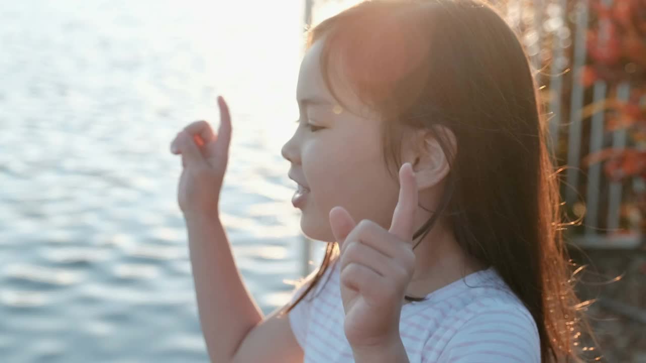 手持拍摄年轻快乐的亚洲女孩笑与太阳耀斑的背景视频素材