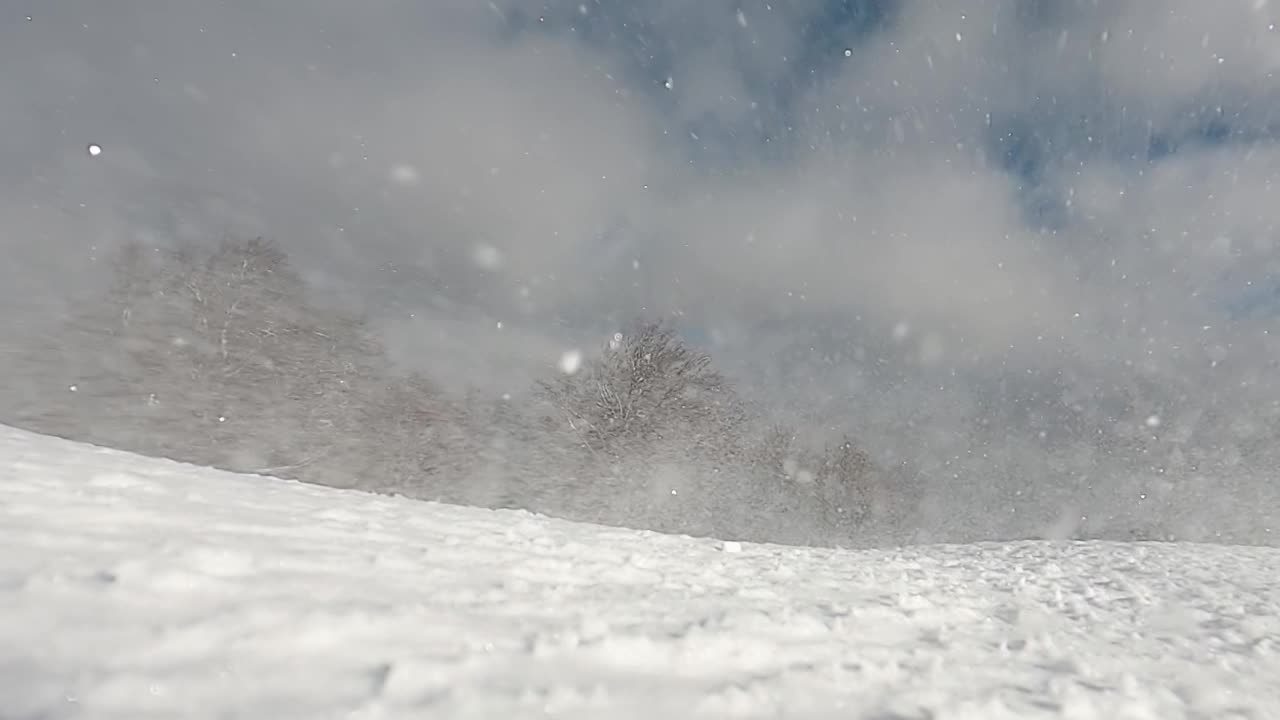 冬季高山滑雪坡上雪堆的雪面，特写。慢动作视频素材