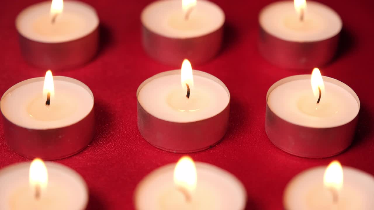 红色背景上的圣诞庆祝蜡烛。烛光为装饰，浪漫情人节视频素材