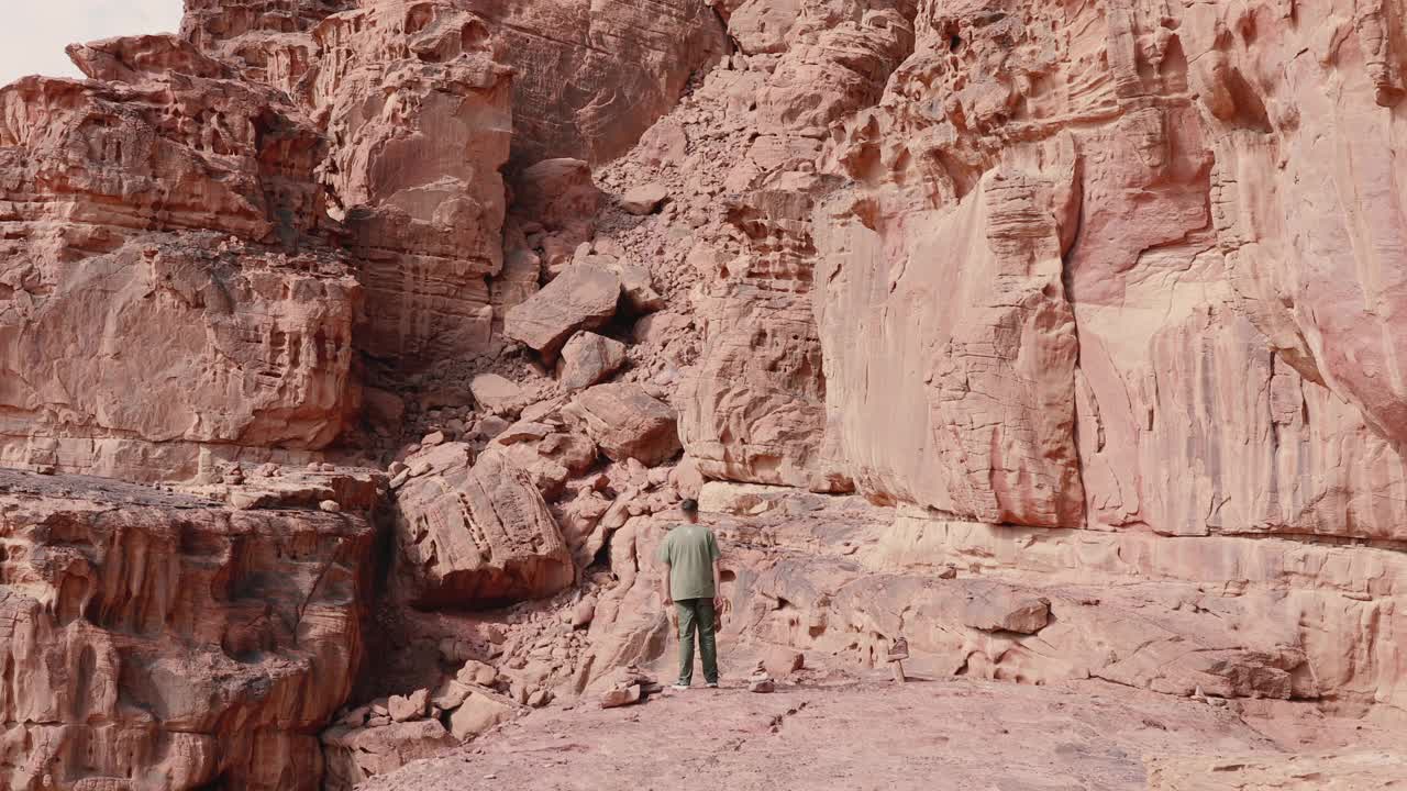 男子旅行者凝视风景在瓦迪拉姆沙漠行走视频素材