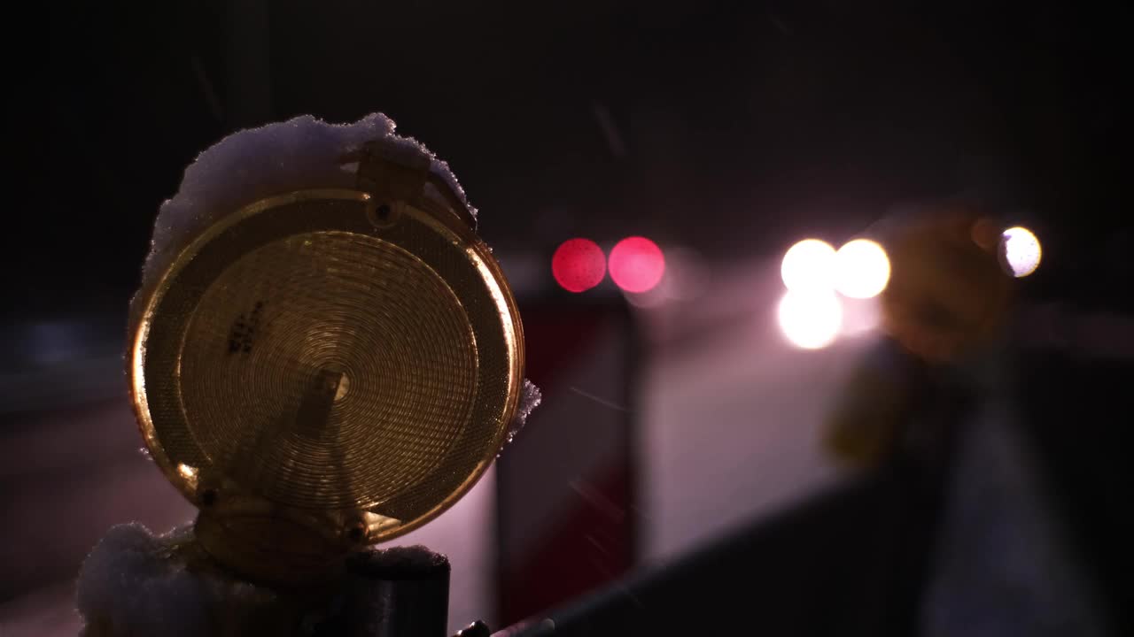 维修道路工程屏障橙色警示灯在冬季夜晚繁忙的结冰道路及交通挤塞情况下依次闪烁视频素材