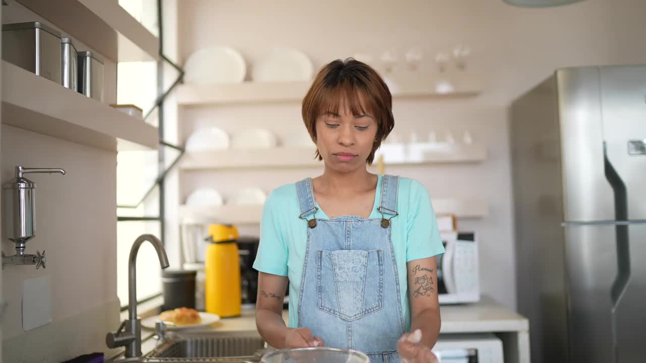 一个年轻女子在家做饭的画像视频素材