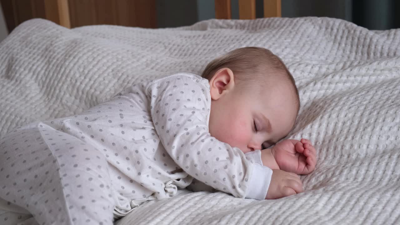 安静可爱的婴儿睡在他的床上在家里的一个房间。睡眠新生儿的概念。6个月大的女婴睡在家里。一个宁静的梦。视频素材