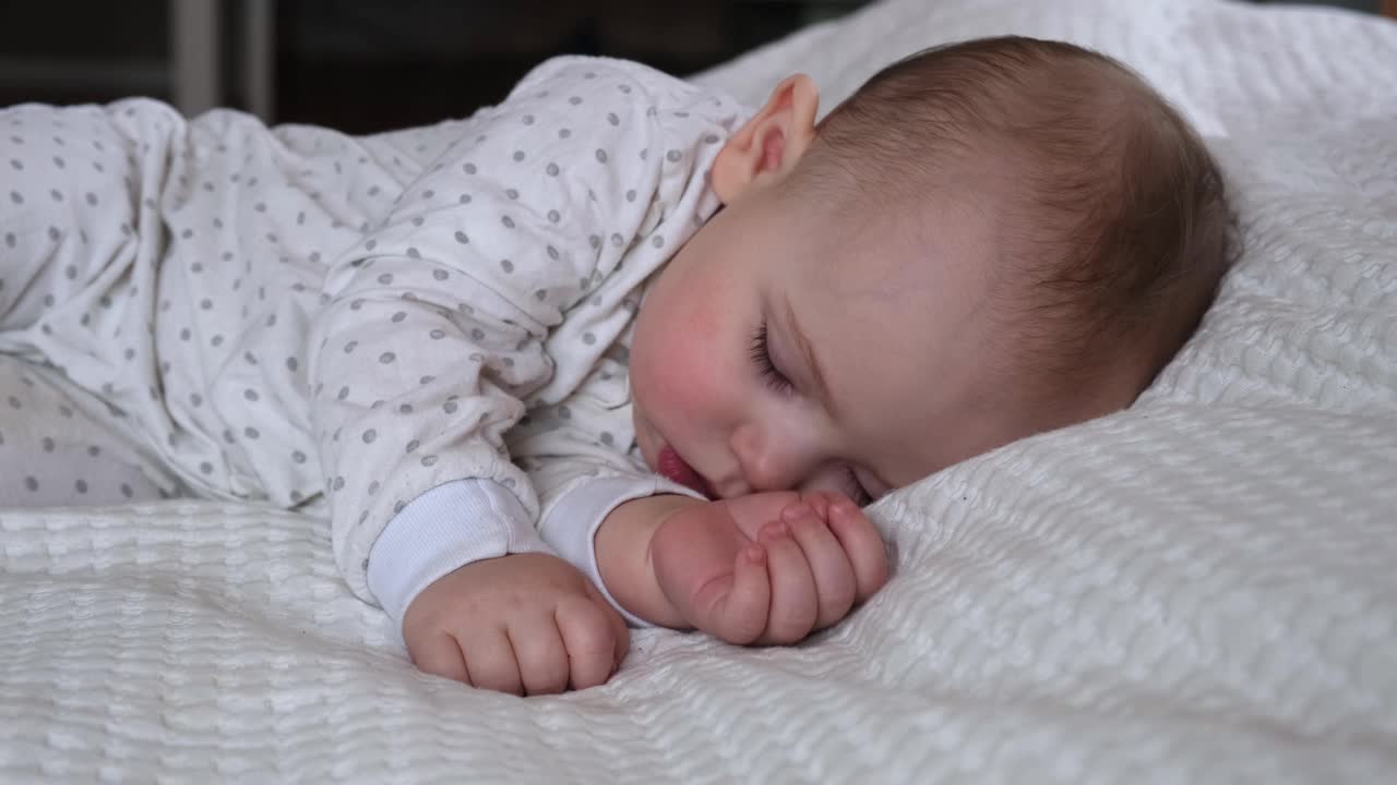 安静可爱的婴儿睡在他的床上在家里的一个房间。睡眠新生儿的概念。6个月大的女婴睡在家里。一个宁静的梦。视频素材